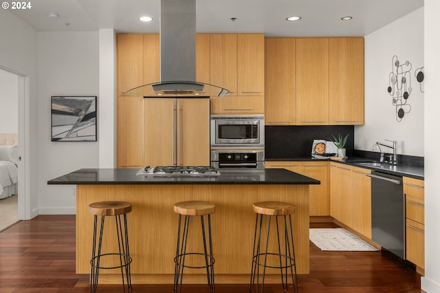 kitchen with a kitchen island, island exhaust hood, stainless steel appliances, a kitchen bar, and dark hardwood / wood-style flooring