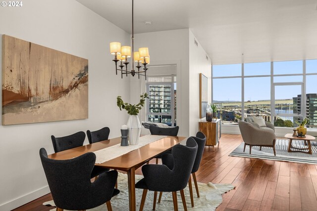 dining room with wood-type flooring and a notable chandelier