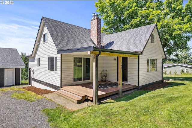 rear view of property with a lawn, a storage shed, and a wooden deck