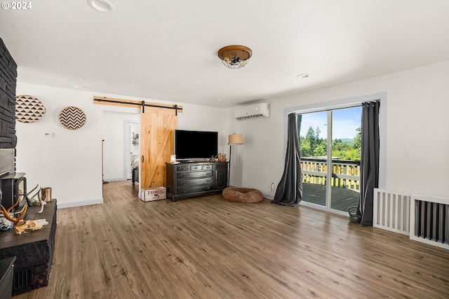 living room with an AC wall unit, a barn door, and dark hardwood / wood-style floors