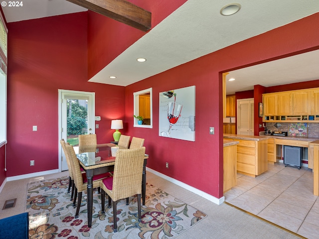 dining room featuring light tile patterned floors and beamed ceiling