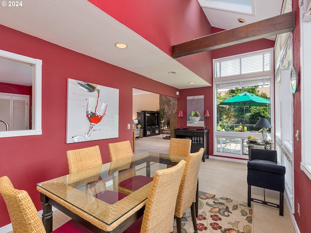 carpeted dining room with a high ceiling