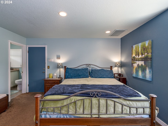 carpeted bedroom with a textured ceiling and connected bathroom