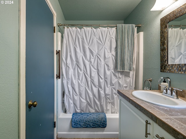 bathroom featuring shower / bathtub combination with curtain and vanity