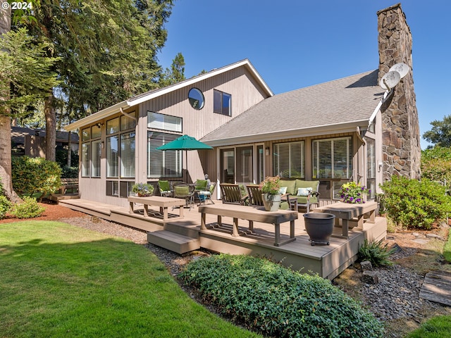 back of house with a lawn, a wooden deck, a sunroom, and an outdoor living space