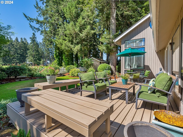 wooden terrace with an outdoor hangout area and a storage shed