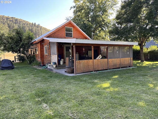 view of front of house featuring a mountain view and a front lawn