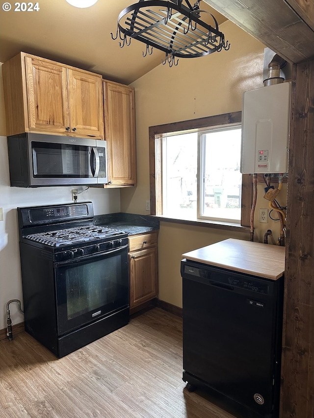 kitchen featuring tankless water heater, vaulted ceiling, light hardwood / wood-style floors, and black appliances