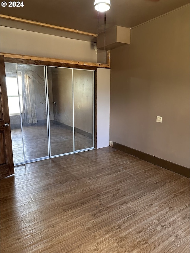 unfurnished bedroom featuring hardwood / wood-style flooring and a closet