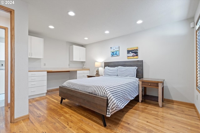 bedroom featuring built in desk and light hardwood / wood-style floors