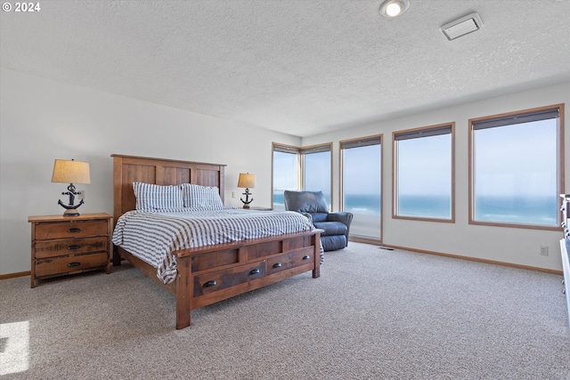 bedroom with a textured ceiling and light carpet