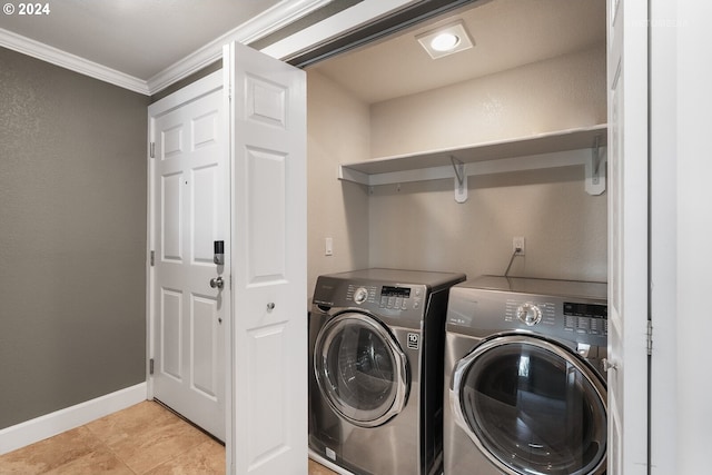 washroom featuring washing machine and dryer, ornamental molding, and light tile patterned floors