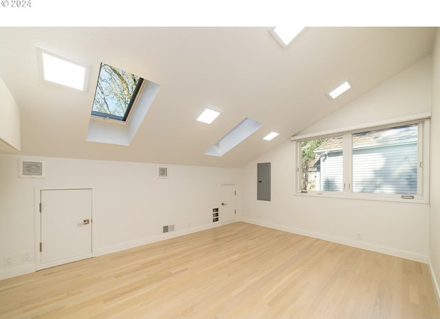 additional living space featuring a skylight, electric panel, and light wood-type flooring