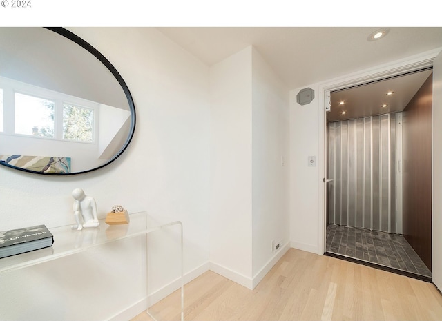 foyer entrance featuring elevator and light hardwood / wood-style flooring