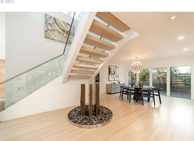 dining space featuring light wood-type flooring and a notable chandelier