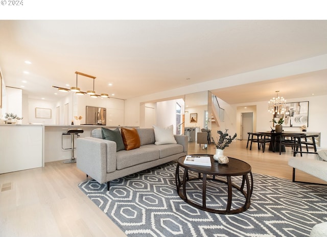 living room featuring an inviting chandelier and light hardwood / wood-style flooring