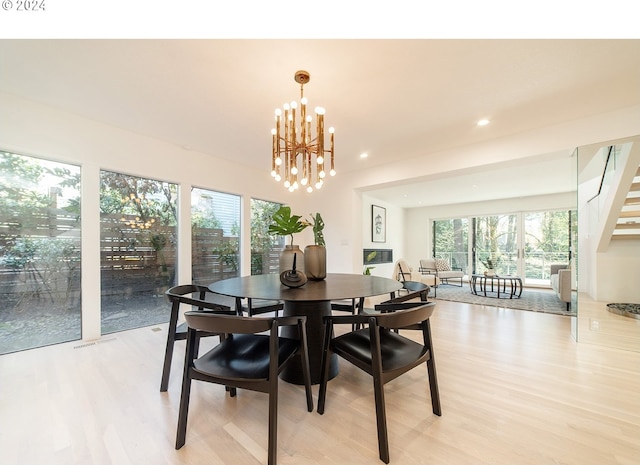 dining space with a chandelier, light hardwood / wood-style flooring, and a healthy amount of sunlight