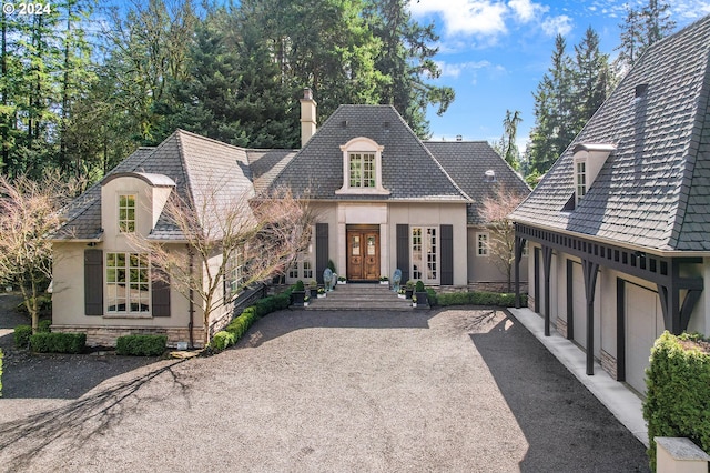 french country inspired facade featuring a garage