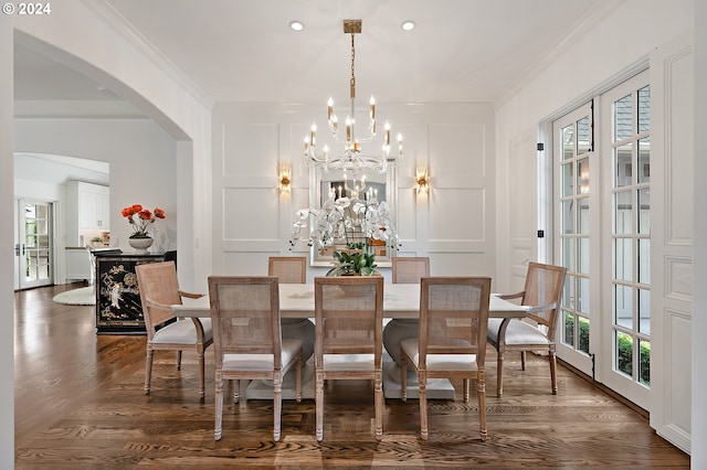 dining space with crown molding, an inviting chandelier, and dark hardwood / wood-style flooring