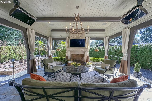 sunroom with an outdoor fireplace, wood ceiling, and a chandelier