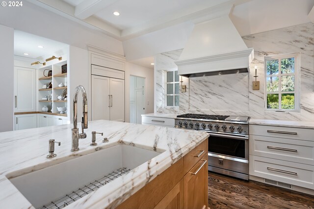 kitchen with white cabinetry, light stone counters, stainless steel stove, dark hardwood / wood-style floors, and custom range hood