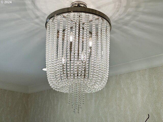 interior details with crown molding, an inviting chandelier, and carpet