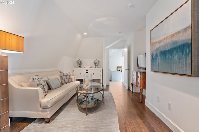 living room featuring lofted ceiling and light hardwood / wood-style floors