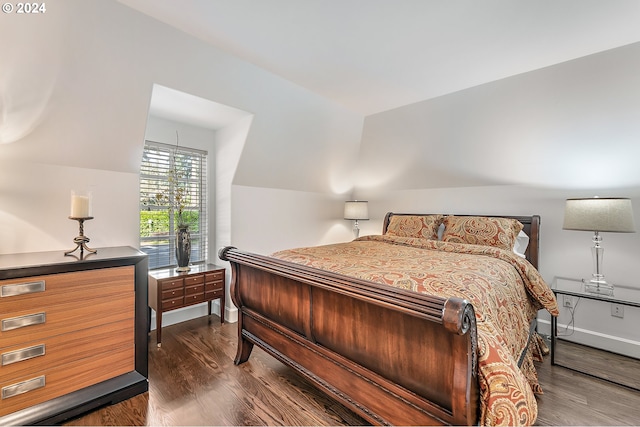 bedroom with vaulted ceiling and dark hardwood / wood-style floors