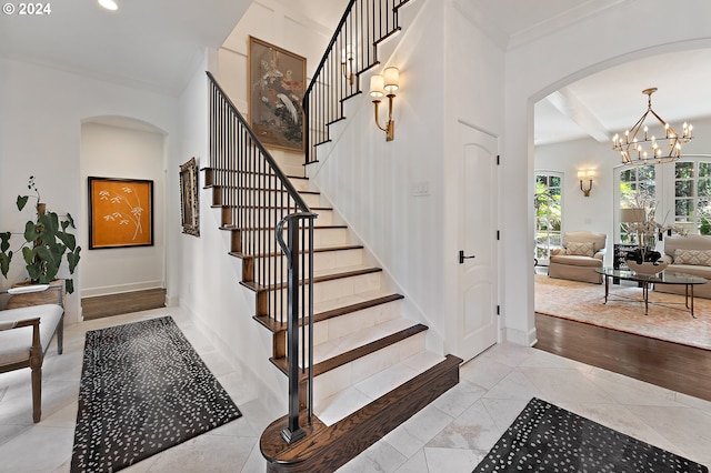 staircase featuring ornamental molding, a chandelier, and hardwood / wood-style floors