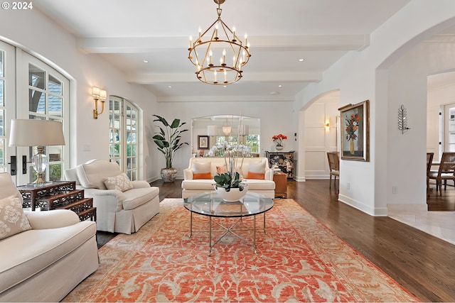 living room featuring hardwood / wood-style flooring, beam ceiling, and a notable chandelier