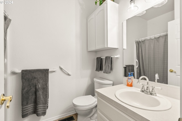 bathroom featuring vanity, curtained shower, and toilet