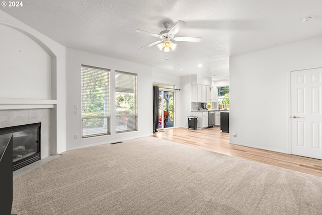 unfurnished living room featuring a textured ceiling, a healthy amount of sunlight, and a fireplace