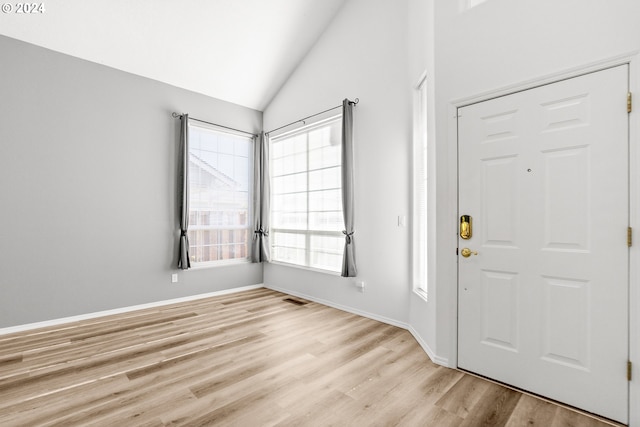 foyer with lofted ceiling and light wood-type flooring