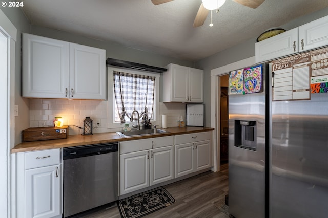 kitchen with sink, dark wood-type flooring, wooden counters, white cabinets, and appliances with stainless steel finishes