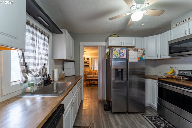 kitchen featuring white cabinets, wood counters, and stainless steel appliances