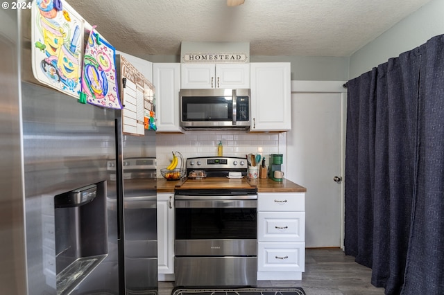 kitchen featuring wood counters, tasteful backsplash, dark hardwood / wood-style flooring, white cabinetry, and stainless steel appliances