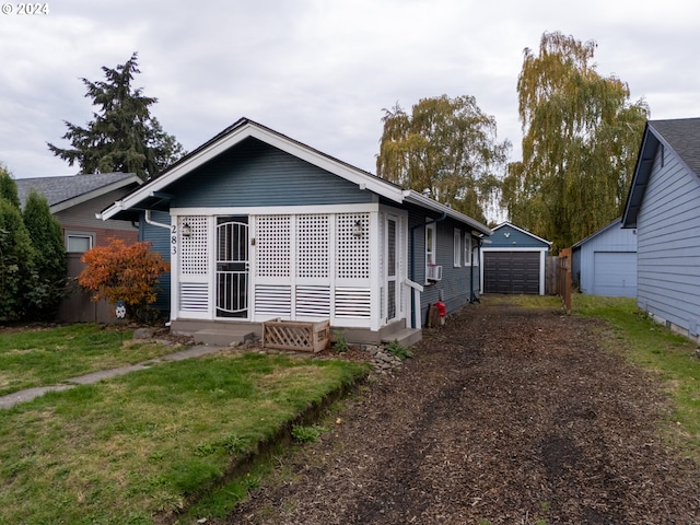 exterior space featuring cooling unit, a garage, an outbuilding, and a front yard