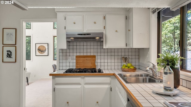 kitchen featuring tile countertops, white cabinetry, and gas cooktop