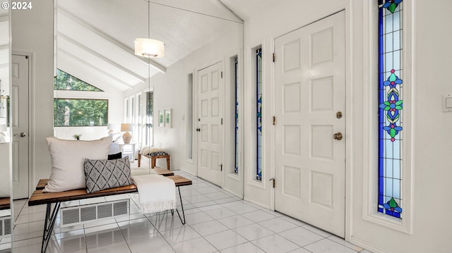 tiled foyer featuring lofted ceiling with beams