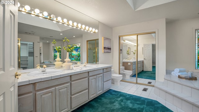 bathroom with tile patterned floors, vanity, toilet, and a textured ceiling