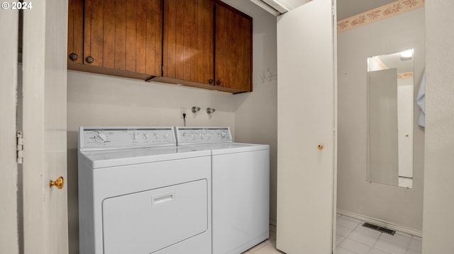 laundry room featuring separate washer and dryer and cabinets