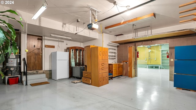 garage with white refrigerator and a garage door opener