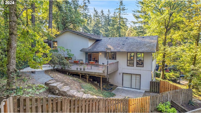 back of house with a garage and a deck