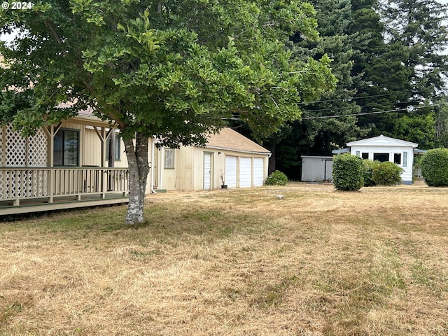 view of yard featuring a garage and an outbuilding