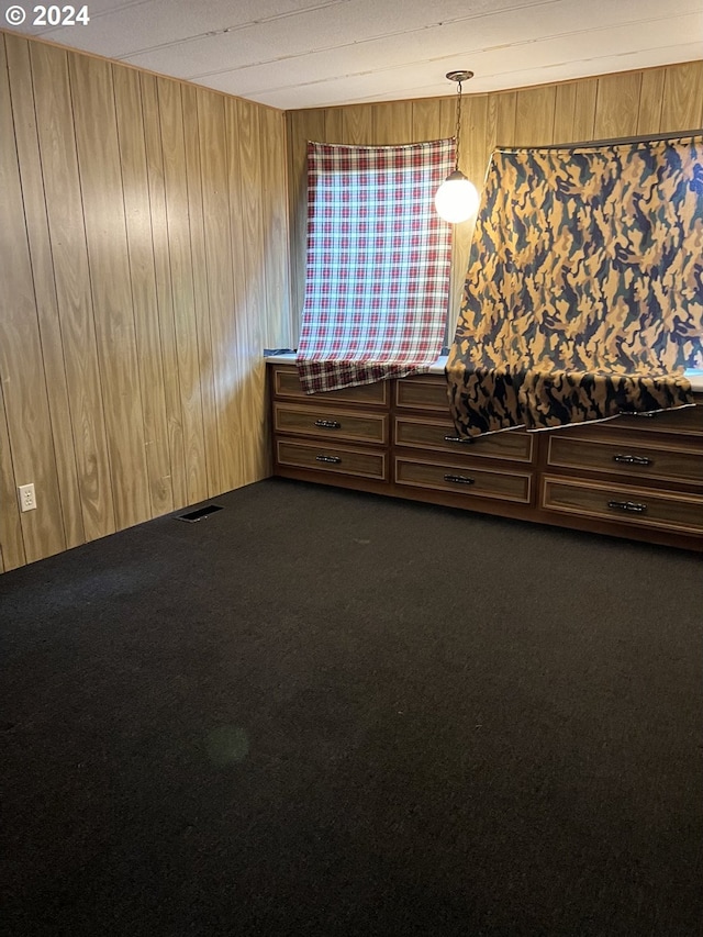 empty room with wooden walls and dark carpet