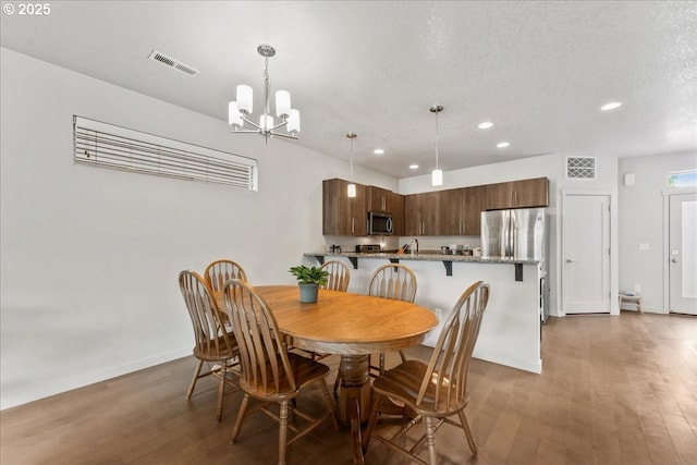 dining space featuring recessed lighting, a chandelier, dark wood-style flooring, baseboards, and a textured ceiling