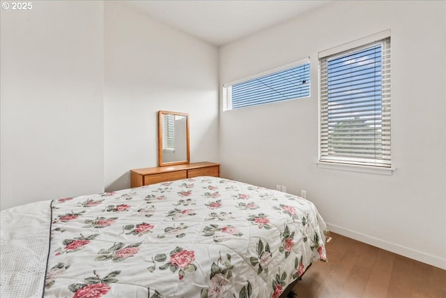 bedroom featuring wood finished floors and baseboards