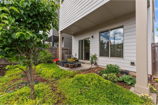 doorway to property featuring fence and central air condition unit
