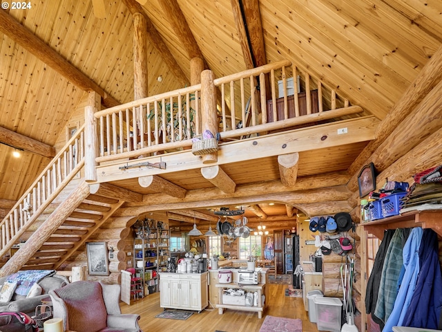 unfurnished living room with rustic walls, high vaulted ceiling, light hardwood / wood-style floors, and wooden ceiling