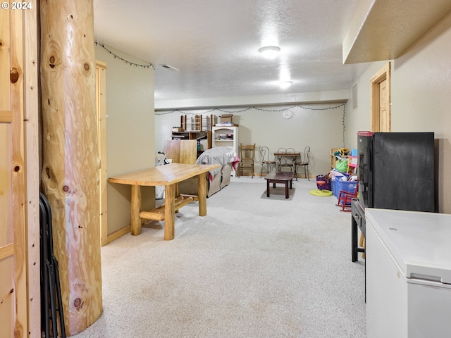 rec room featuring a textured ceiling and carpet